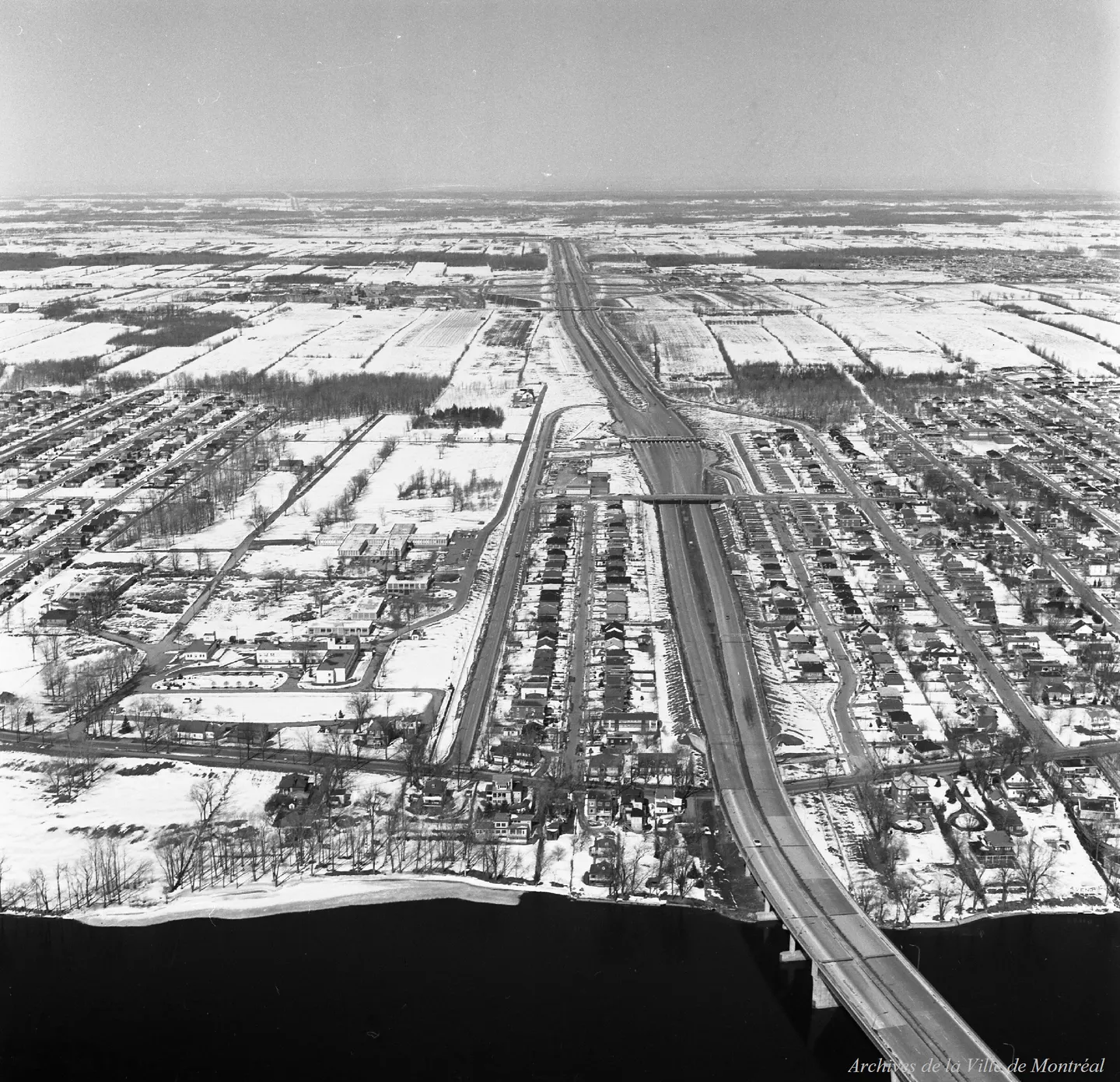 Photo aérienne d’un pont s’étendant sur une longue route dans un paysage urbain enneigé
